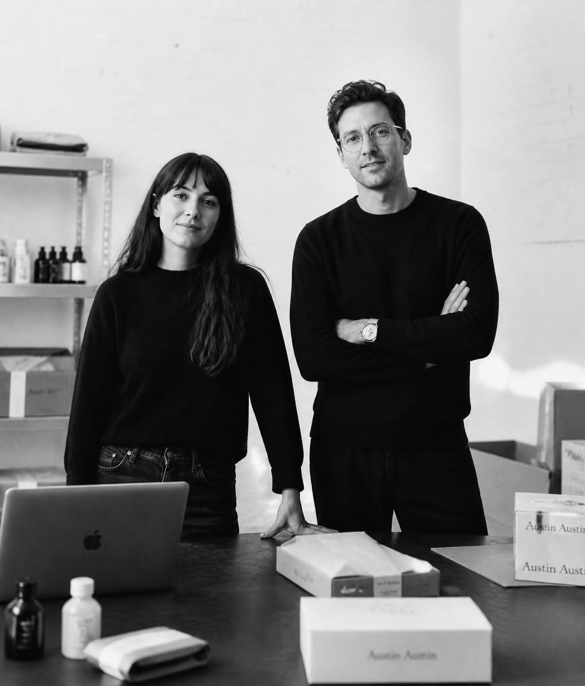 Black and white editorial portrait of the Komerce founders in a studio with product boxes